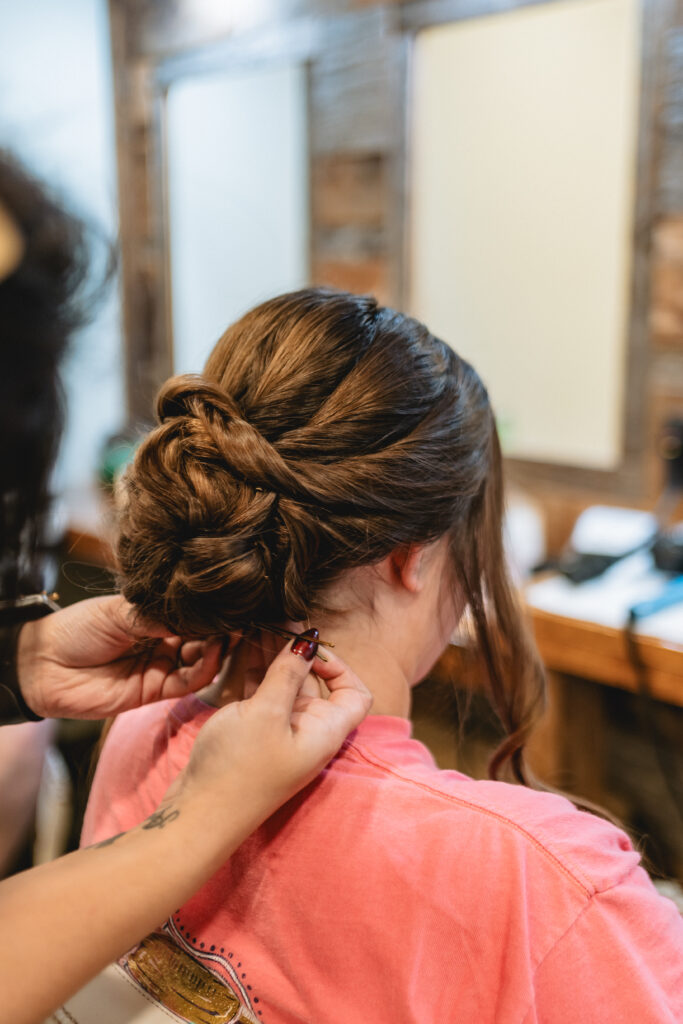 bride getting her hair done in an updo