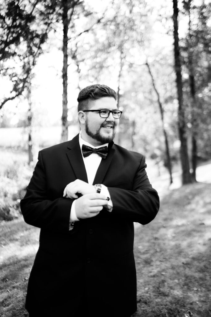 groom smiling and adjuting cuff link