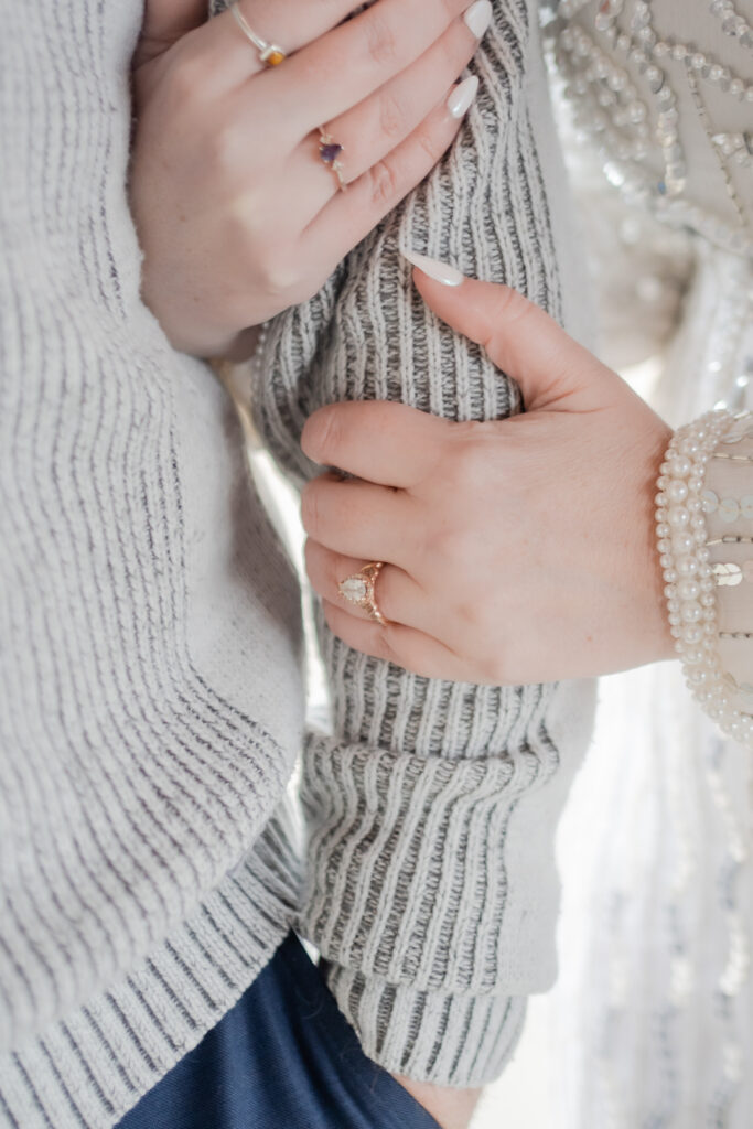 Bride holding grooms arm and showing ring