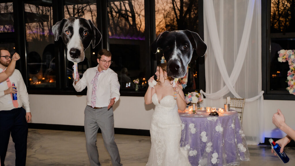 bride and groom reception dancing holding photos of their pets with sunset in the background