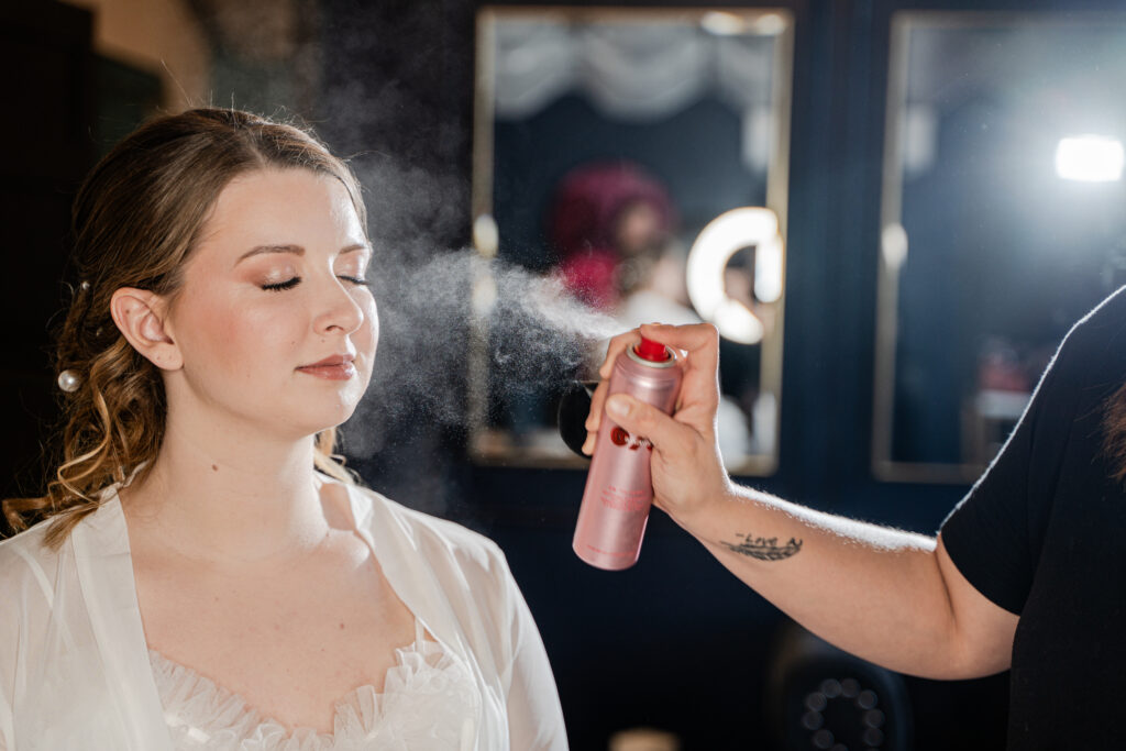 Bride getting face setting spray on her