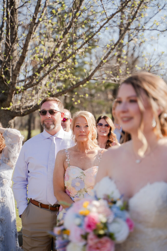 mother of the bride emotional wedding photo looking at bride walking down the isle