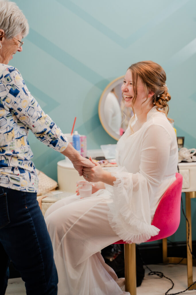 Bride getting ready holding hands with grandma