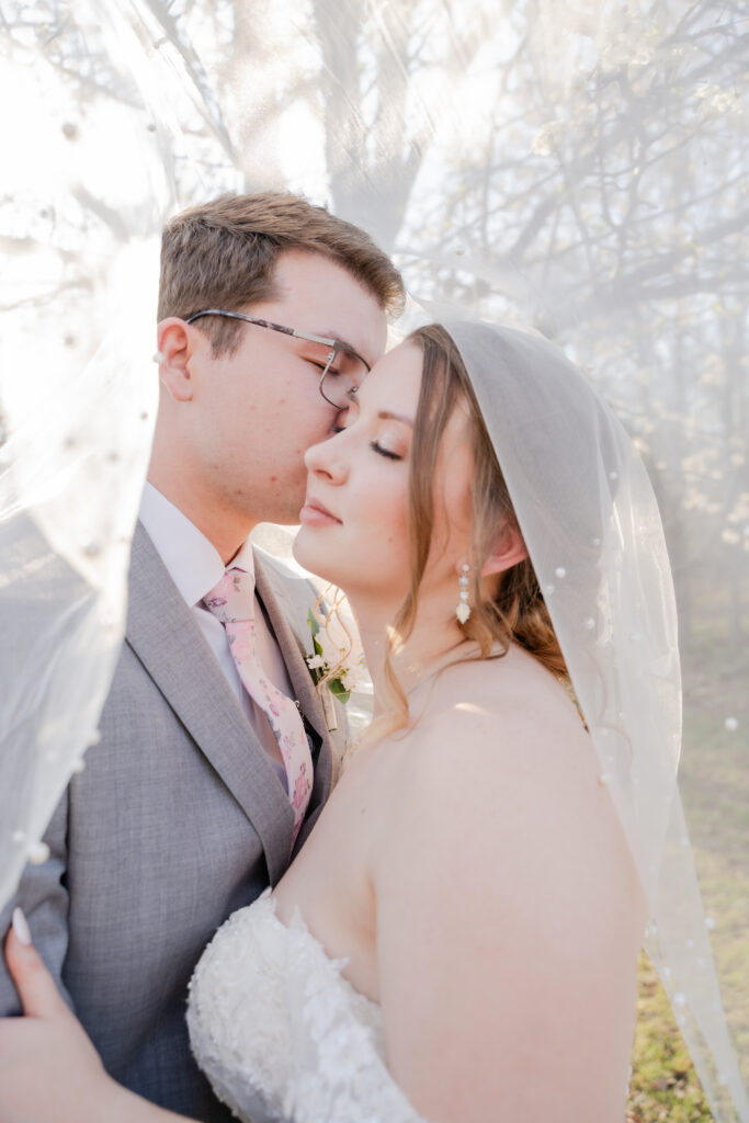 bride and groom under a veil wedding photography