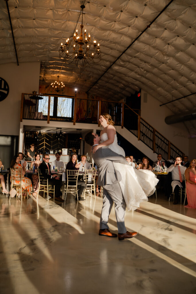 wedding first dance groom lifts bride at sunset inside echo creek